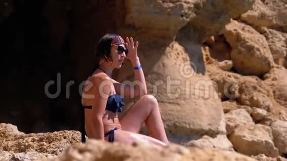坐在红海边埃及落基海滩悬崖上的性感女孩视频的预览图