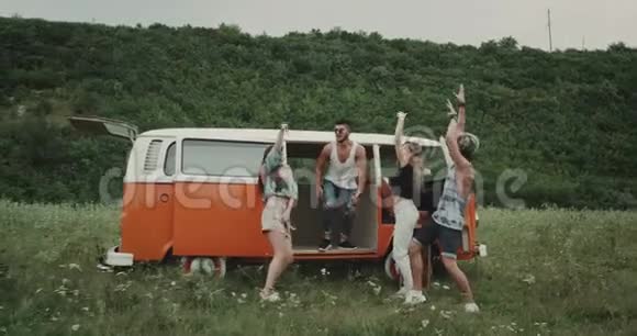 复古橙色面包车在大自然中间的朋友们玩得很开心跳舞视频的预览图