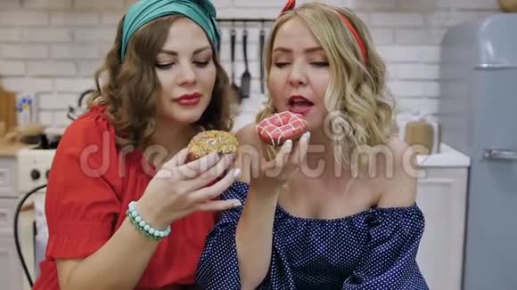 两个女人在饮食中吃美味的甜甜圈慢动作视频的预览图