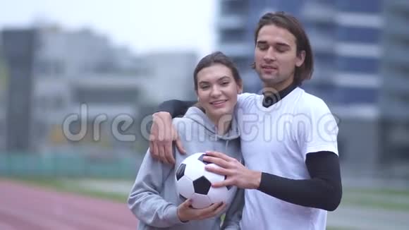一对漂亮的年轻情侣在户外运动时的肖像穿着运动服的帅哥亲吻女友视频的预览图