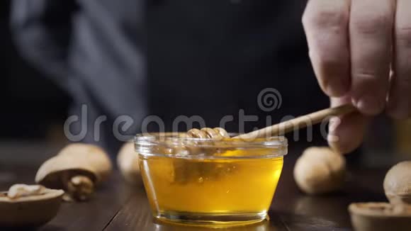 厨师蘸木蜂蜜用液体蜂蜜粘在玻璃碗上用蜂蜜烹饪用天然蜂蜜做甜食视频的预览图