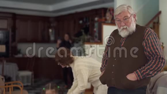 大胡子大人站在大客厅里摇头在后台祖母帮助小女孩起床视频的预览图