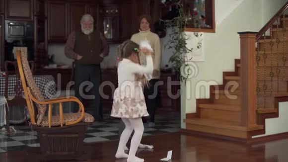 两个有趣的活跃的孙女在震惊的背景下放纵奔跑和扔纸片在地板上视频的预览图