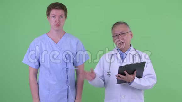 成熟的日本男子医生和年轻男子病人一起解释视频的预览图
