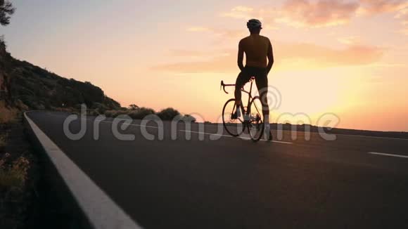 骑自行车的人穿着黄色的t恤在山上看日落健身后休息钢铁侠视频的预览图