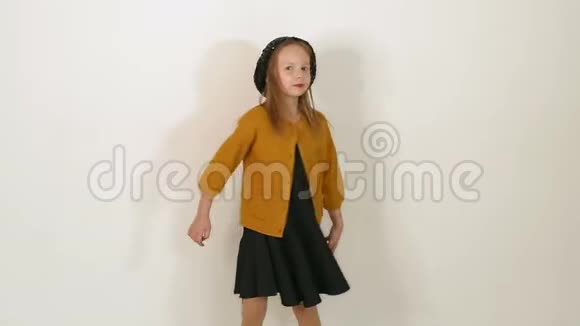 一个穿着黑帽子黑衣服和棕色夹克的小女孩在工作室的肖像视频的预览图
