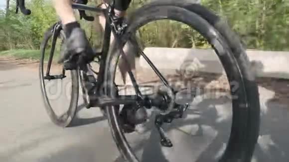骑自行车的骑自行车的人腿部肌肉强壮在自行车上跟随骑自行车的腿的镜头慢动作视频的预览图