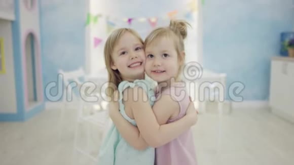 两个小女孩站在镜头前拥抱在一起视频的预览图