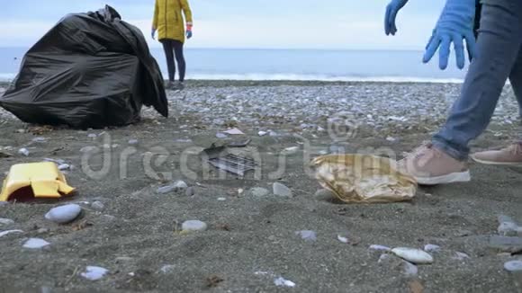 志愿者在秋天清理海滩上的垃圾环境问题视频的预览图