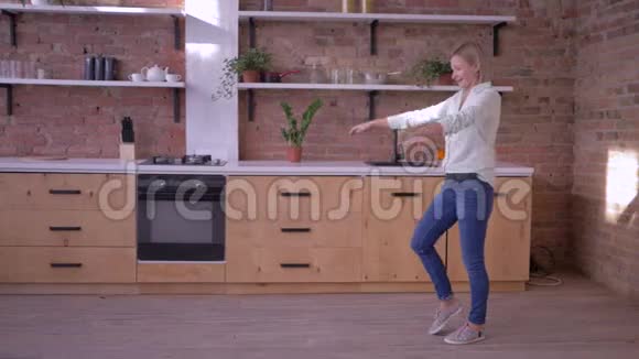 运动开朗的女人在家的厨房里慢动作地做体操翻身视频的预览图