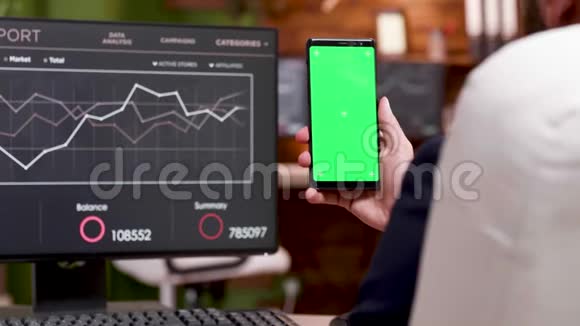 后视白种人商人持手机与绿色屏幕视频的预览图