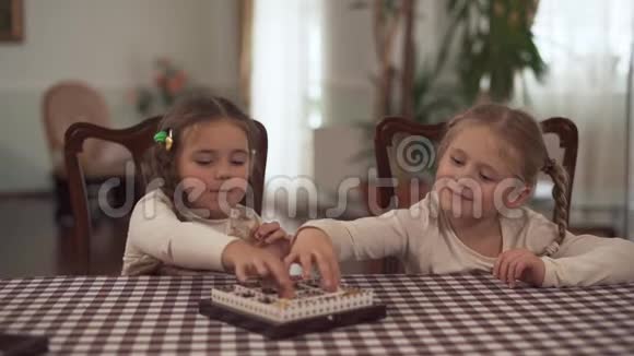 两个梳着辫子的可爱女孩从糖果盒里拿出糖果在视频的预览图