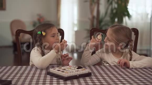 两个可爱的小妹妹晚饭后吃巧克力美味的无糖糖果球你非常喜欢它慢动作视频的预览图