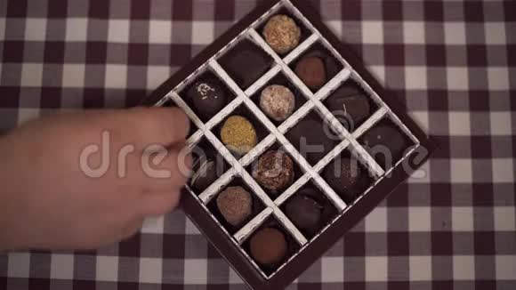 大人和孩子把糖果放回盒子里孩子和祖父母在家吃巧克力特写镜头视频的预览图