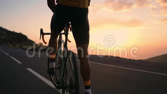骑自行车的人穿着黄色的t恤在山上看日落健身后休息铁人从视频的预览图