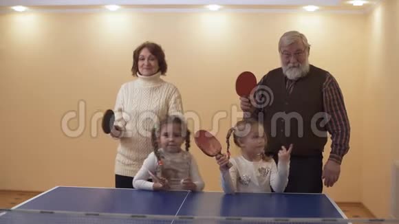 爷爷奶奶带着可爱的小孙女准备打网球等待一拳慢动作视频的预览图