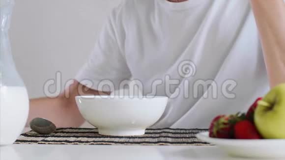 女人手在碗里倒牛奶和玉米片作为早餐视频的预览图