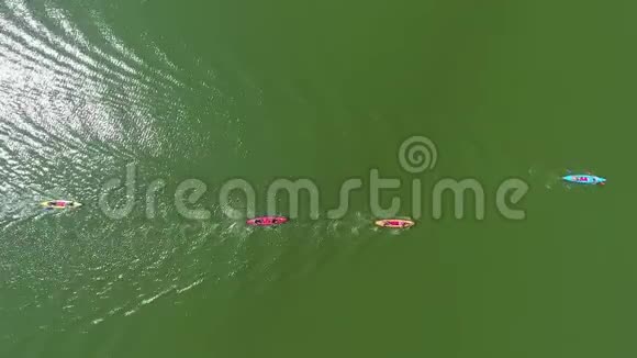 在河面上悬挂着划手的彩色皮划艇上的高空反射阳光视频的预览图