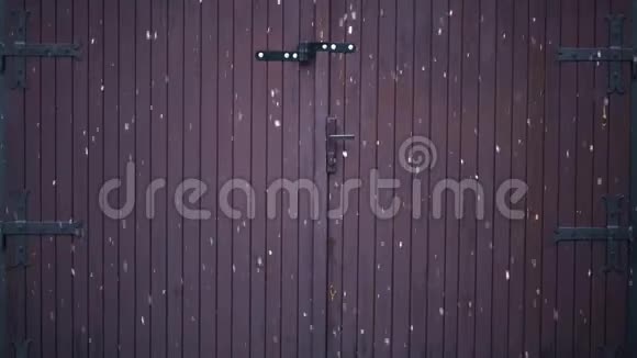 一个旧的金属铰链的木制车库门一个大金属铰链大片雪花在冬天飘落视频的预览图