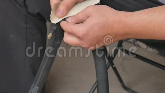 骑自行车的人或修理工清理被刺破的轮胎自行车双手合拢自行车轮胎爆胎一个人在修理视频的预览图