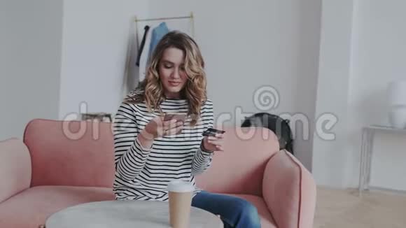 一个自然卷曲的黑发女人通过手机支付信用卡支付账单有魅力的女孩在网上购物视频的预览图