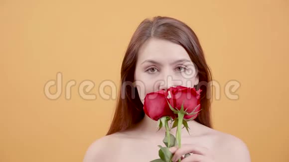 迷人的年轻女子手中拿着玫瑰摆姿势拍照视频的预览图
