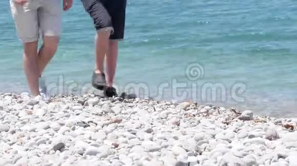 几个男孩在白色的沙石海滩上靠近清澈的地中海视频的预览图