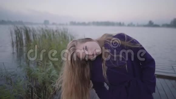 湖底的年轻女子把头发往另一边扯微笑着视频的预览图