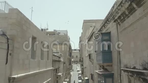 垂直下降无人机飞过美丽的老街瓦莱塔马耳他旧的老式的窗户阳台4K视频的预览图