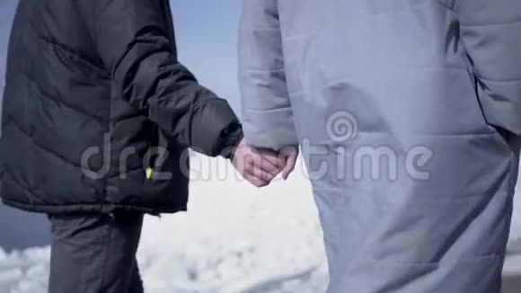 靠近男人走路女人牵着手在背景上看到一个下雪的北极或南极一对夫妇视频的预览图
