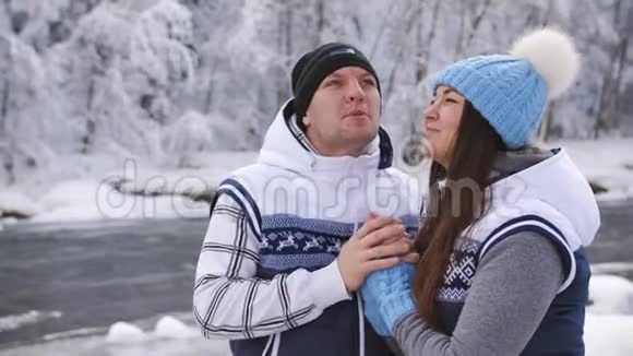 幸福的家庭夫妇旅行者在山河附近享受冬天的自然视频的预览图
