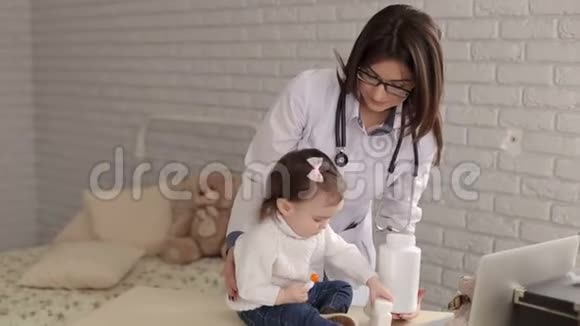 好的女医生和一个女孩玩在儿童医生的接待处视频的预览图