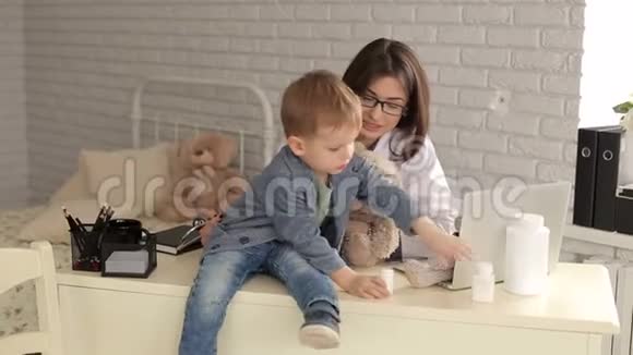 一位年轻的女医生在一家儿童诊所办公室里和一个小男孩玩耍视频的预览图