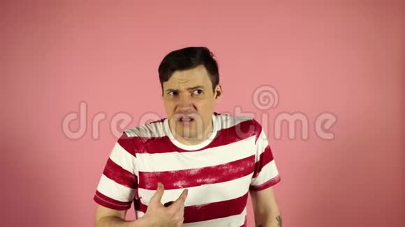 沮丧的男人30多岁的镜头在粉红色的背景上困惑地挠头困惑的男人抓着他视频的预览图