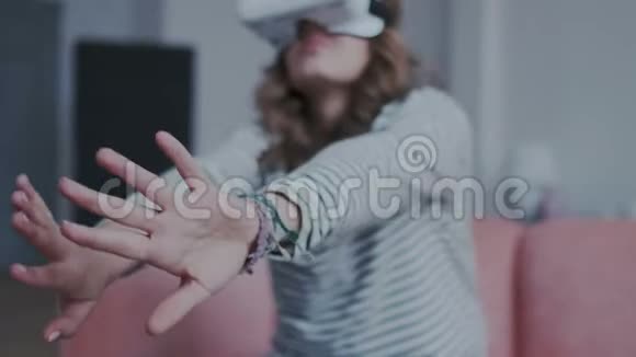 在家中使用虚拟现实眼镜时女性手在空间中移动的特写镜头女孩获得经验视频的预览图