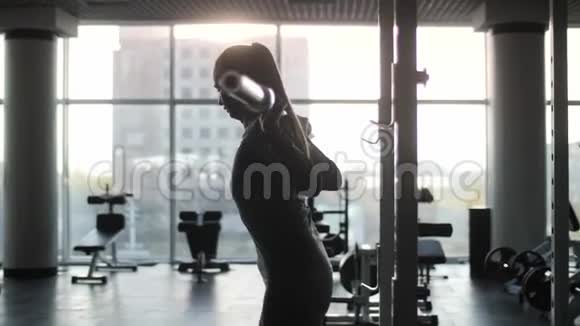 运动的中年妇女在健身房里用杠铃做运动视频的预览图
