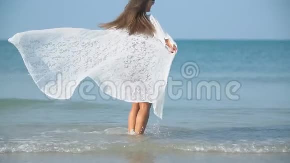 穿着泳衣的女孩走在浅海上视频的预览图