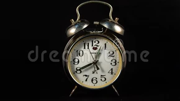 一个古老的时钟闹钟的反向延时停止运动会在黑色背景下计算时间视频的预览图