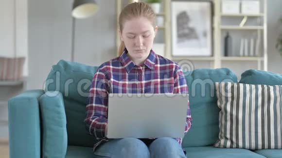 年轻女子手提电脑头痛视频的预览图
