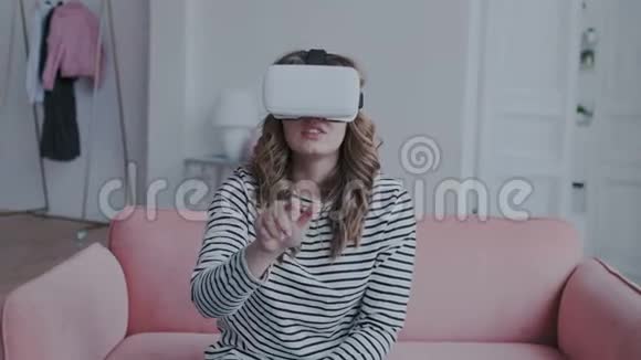 漂亮的自然黑发女孩在家里使用虚拟现实眼镜她在与人交往的时候动了手视频的预览图