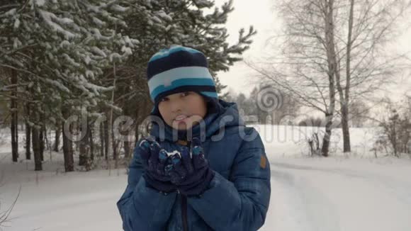 少年男孩从他的手里吹雪视频的预览图