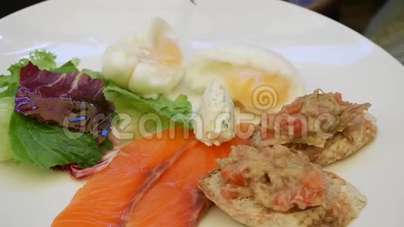 女人吃早餐用西红柿鳄梨和鲑鱼奶酪和蔬菜煮鸡蛋快乐视频的预览图
