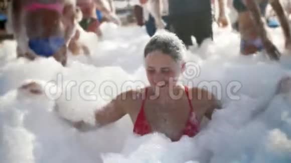 4k视频阳光明媚的海滩派对上一群满脸肥皂泡沫的年轻女子笑嘻嘻的视频的预览图