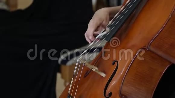 女人用大提琴演奏大提琴关闭女性手玩大提琴与大提琴弓古典乐团视频的预览图