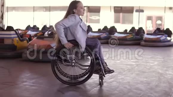 残疾残疾的残疾青年妇女坐轮椅在电动汽车的吸引面上跳舞视频的预览图