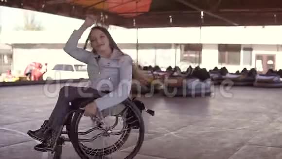 残疾残疾的残疾青年妇女坐轮椅在电动汽车的吸引面上跳舞视频的预览图