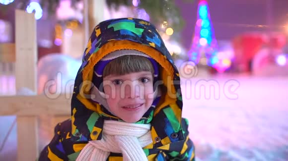 一个可爱的小男孩的肖像圣诞节可爱的小男孩在圣诞城户外玩得很开心圣诞快乐的男孩视频的预览图
