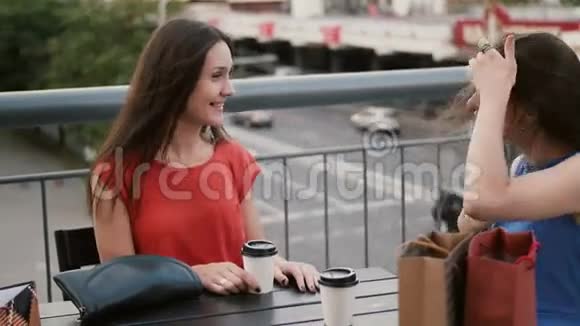 美丽的女人喝咖啡在咖啡馆里交流看看交通购物后交谈4k视频的预览图