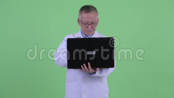 快乐成熟的日本男子医生思考笔记本电脑视频的预览图