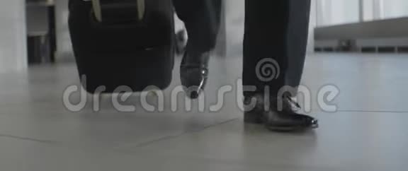 一个穿着黑色鞋子和裤子带着行李在室内行走的人面目全非视频的预览图